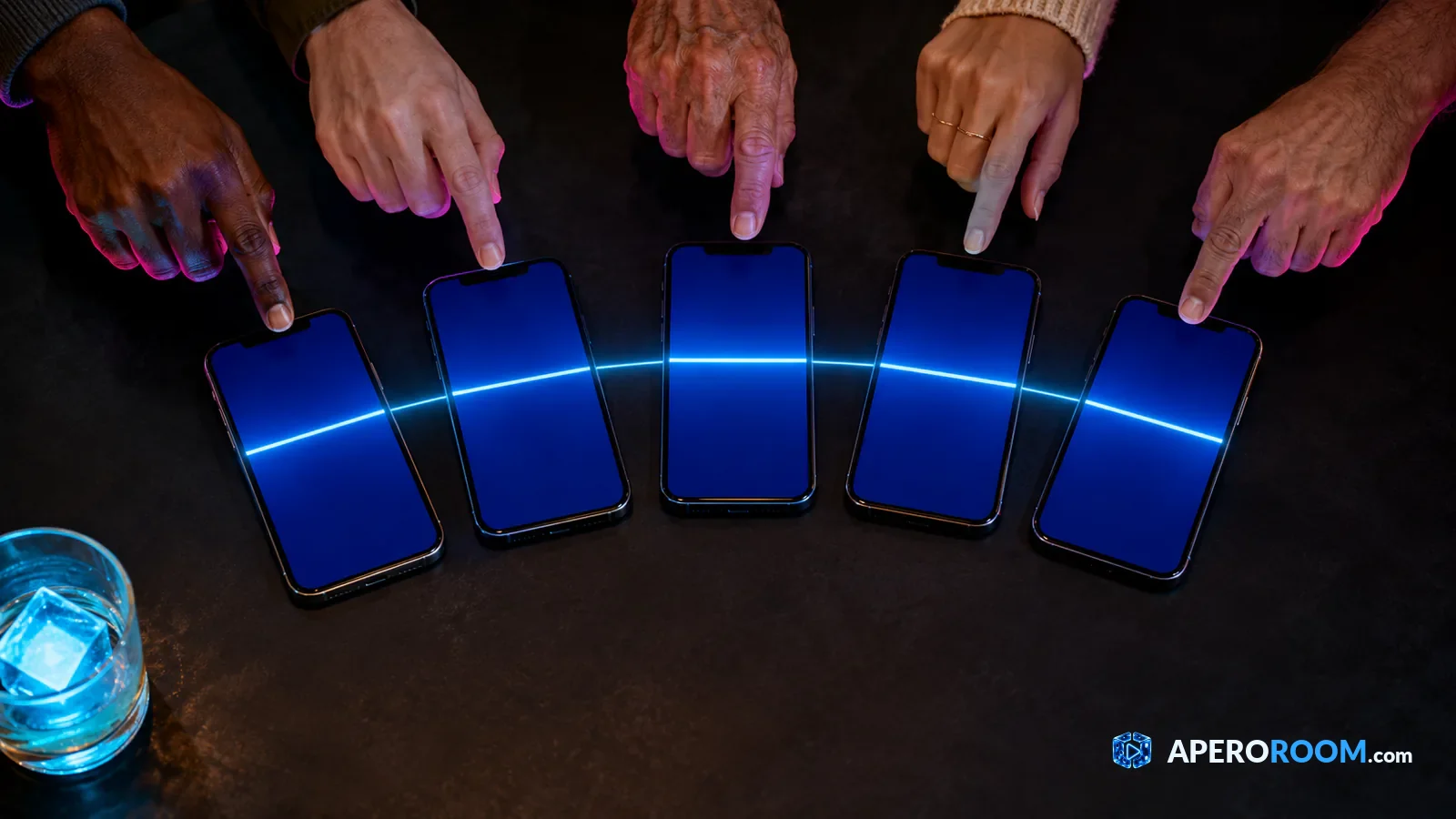 Répondre tous au même signal pour une partie équitable Cinq doigts suspendus au-dessus de cinq téléphones reliés par un même trait de lumière.